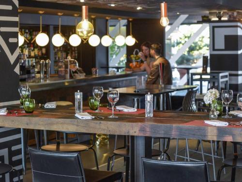 un bar en un restaurante con una mesa con copas de vino en Novotel Metz Centre, en Metz