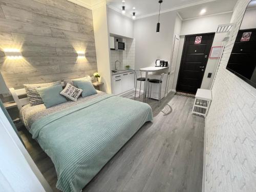 a bedroom with a large bed and a kitchen at Tiffany Apartment in Irpin'