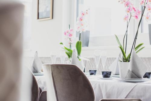 einen Tisch mit einem weißen Tischtuch und Blumen darauf in der Unterkunft Boutique Hotel Edelmanns in Kematen in Tirol