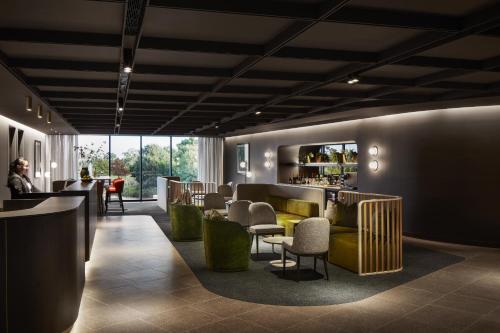 a lobby with a yellow couch and chairs and a bar at Punthill Caroline Springs in Caroline Springs