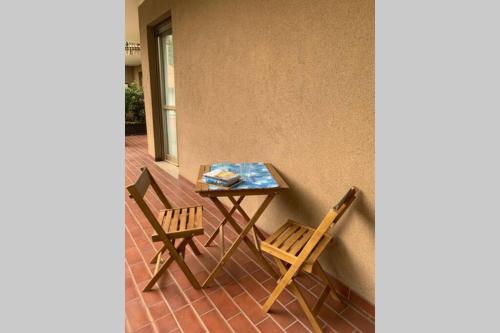 een tafel en 2 stoelen op een patio bij Lario Promenade: family friendly apartment in Como in Como