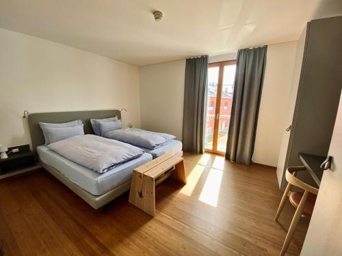 a bedroom with a bed and a wooden floor at Hotel Müller - mountain lodge in Pontresina