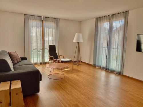 a living room with a couch and a table at Hotel Müller - mountain lodge in Pontresina