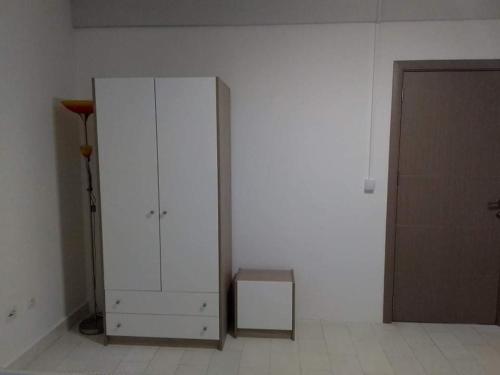 un armadietto bianco in una stanza accanto a una porta di Apartman ZAFIROVI a Gevgelija