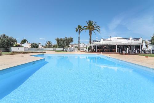 una gran piscina azul junto a un edificio en Casa O12, en Vilamoura