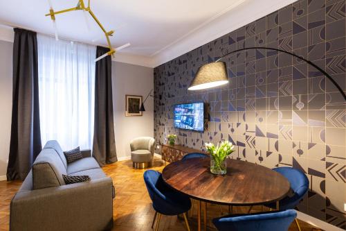 ein Wohnzimmer mit einem Tisch und Stühlen in der Unterkunft CA’MILLA Luxury Apartments Trieste in Triest