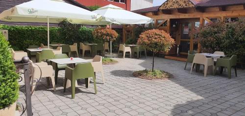 un restaurant avec des tables, des chaises et un parasol dans l'établissement Noblesse Boutique Resort, à Sibiu