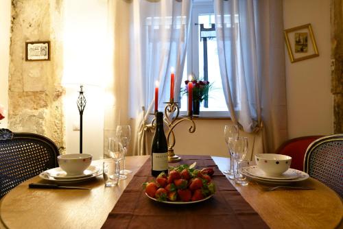 uma mesa com uma garrafa de vinho e um prato de fruta em La Duchesse - Loveroom Moonlove Place Stanislas em Nancy