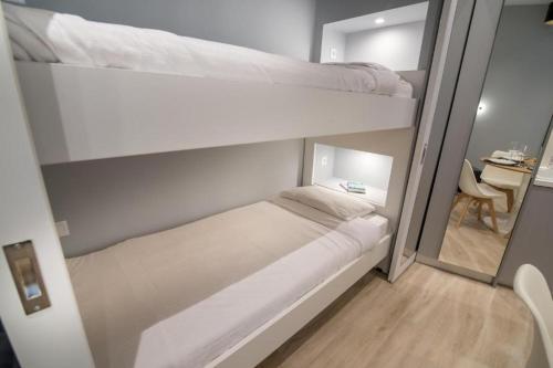 a bedroom with two bunk beds and a table at Preveza Suitestay Apartments Dodonis 28 in Preveza