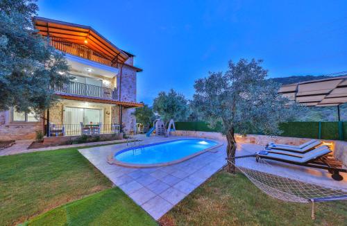 une arrière-cour avec une piscine et une maison dans l'établissement Villa Candan Kaş, à Antalya