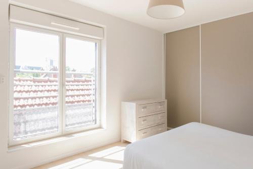 een slaapkamer met een bed en een groot raam bij Zenao Appart'hôtels Troyes in Troyes