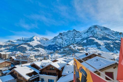 Blick auf eine Stadt mit schneebedeckten Bergen in der Unterkunft Hotel Bristol Relais du Silence Superior in Adelboden