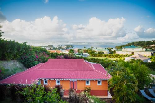 une maison orange avec un toit rouge dans un village dans l'établissement La Suite Villa, à Les Trois-Îlets