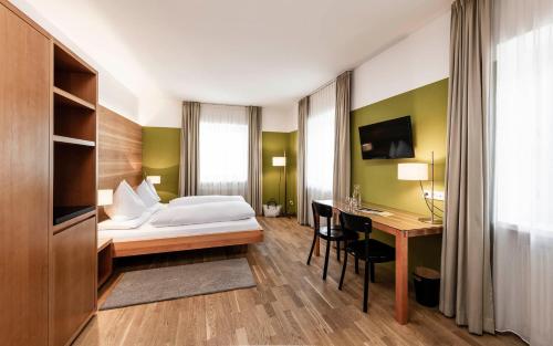 una camera d'albergo con letto e scrivania con computer di Boutique & Gourmet Hotel Orso Grigio a San Candido