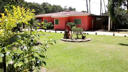 een klein rood huis met een groene tuin bij Complejo Turistico Chuy in Barra del Chuy