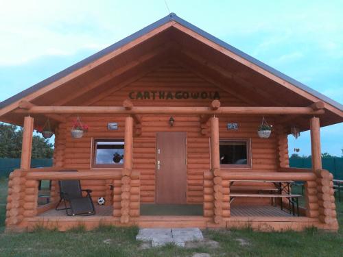 Cette cabane en rondins dispose d'une véranda et d'une porte. dans l'établissement Agroturystyka dom z bali całoroczny, à Turbia