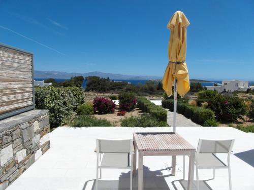 d'une terrasse avec une table et un parasol jaune. dans l'établissement Blue Amaryllis Villas, à Santa Maria