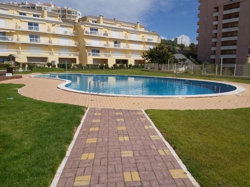 een zwembad voor een groot gebouw bij Sunset Village Apartment - Brisa Da Ericeira in Ericeira