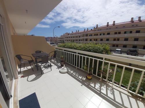 een balkon met een tafel en stoelen en een gebouw bij Sunset Village Apartment - Brisa Da Ericeira in Ericeira