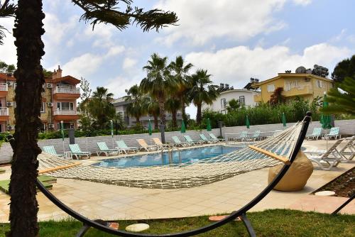 una hamaca en un complejo con sillas y una piscina en Nora Suit Hotel, en Side