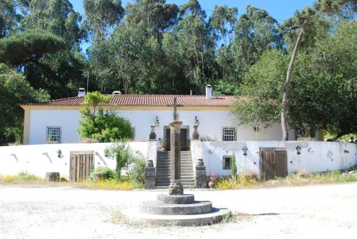 een wit huis met een fontein ervoor bij Quinta do Brejo - Turismo Equestre in Malveira