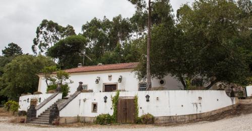 een oud wit huis met een poort en een trap bij Quinta do Brejo - Turismo Equestre in Malveira