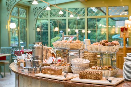 a table with baskets of bread and pastries on it at Ringhotel Mönch`s Waldhotel in Unterreichenbach