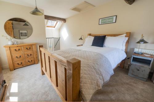 um quarto com uma cama grande e um espelho em Thornes Cottage em Huddersfield