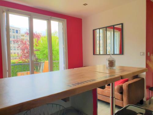 een kamer met een houten tafel voor een raam bij Gare - Polygone Scientifique - Palais de Justice in Grenoble