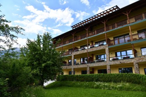 um edifício de apartamentos com varandas e uma sebe em Villa Buchenhain em Ehrwald