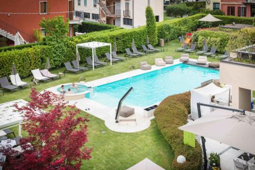 - une vue sur la piscine et ses chaises longues dans l'établissement Enjoy Garda Hotel, à Peschiera del Garda