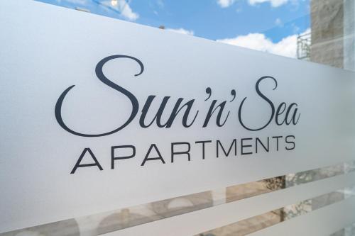 ブドヴァにあるSun and Sea Apartmentsの建物前の日当たりの良い海辺のアパートメントの看板