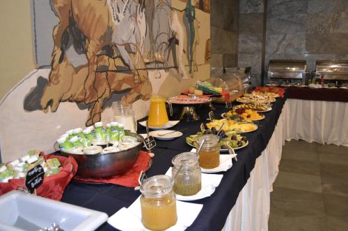 un buffet avec des assiettes de nourriture dans l'établissement Pousada de Angra do Heroismo Castelo de S. Sebastiao, à Angra do Heroísmo