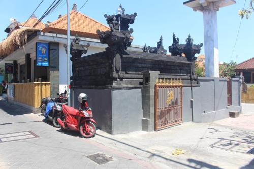 a red scooter parked in front of a building at Jukung Villas Kuta in Kuta