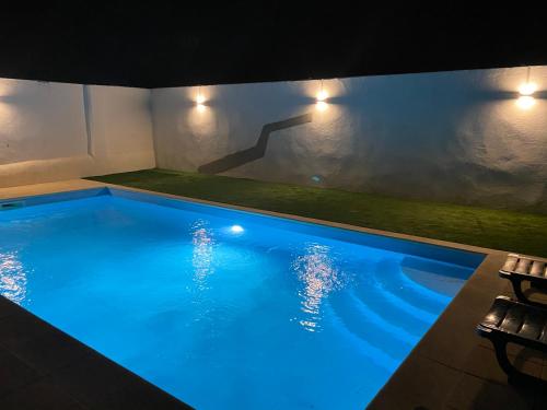 uma grande piscina com iluminação azul numa casa em Painel de Monsaraz em Reguengos de Monsaraz