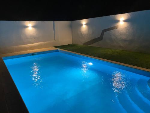 uma grande piscina com iluminação azul numa casa em Painel de Monsaraz em Reguengos de Monsaraz