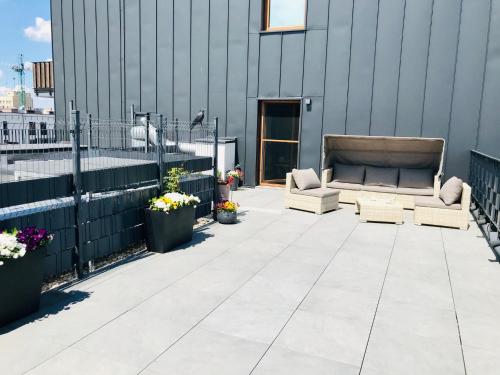 a patio with two couches and flowers on a building at Stadium Apart Terrace in Warsaw