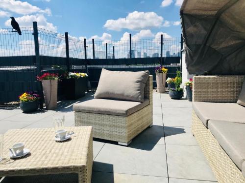 a patio with a couch and a table and chairs at Stadium Apart Terrace in Warsaw