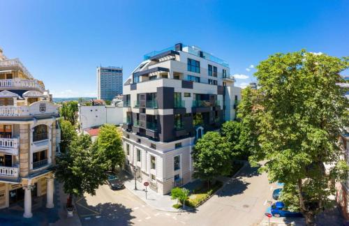 an overhead view of a tall white building with trees at Sea&City Deluxe Apartment - Top Center Varna in Varna City