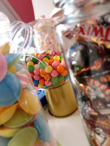 una ciotola di caramelle in un barattolo accanto ad altri snack di Candypartment Sweets 'n Sleep a Gelsenkirchen