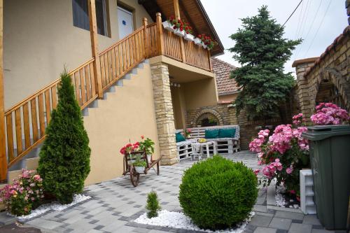 a house with a balcony with a bench and flowers at Golden BIS, Subotica in Subotica