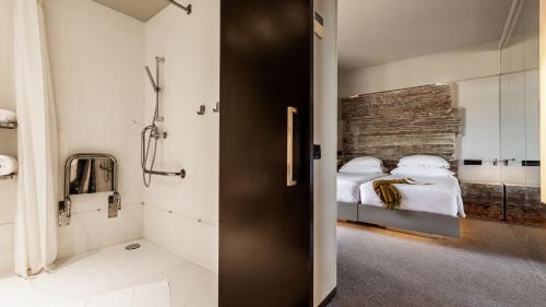 a bathroom with a bed and a shower in a room at Vitoria Stone Hotel in Évora