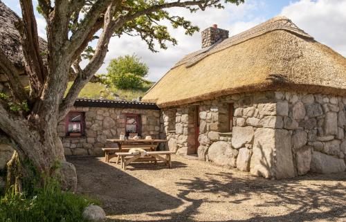 kamienny budynek ze stołem piknikowym przed nim w obiekcie Cnoc Suain w Galway