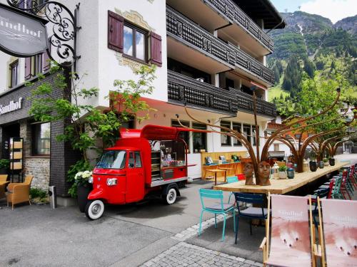 a red food truck parked in front of a building at Hotel Sandhof in Lech am Arlberg