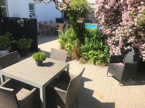 un patio con tavolo, sedie e fiori di Kathrines Bed & Breakfast a Svendborg