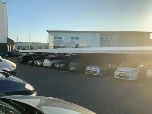 ein Parkplatz mit Autos vor einem Gebäude in der Unterkunft Ibis Budget Le Havre Les Docks in Le Havre