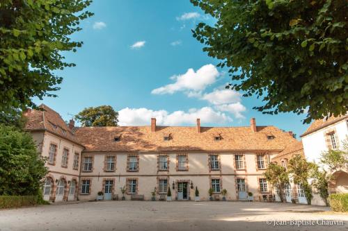 una mansión antigua con techo rojo en Château de la Cour Senlisse, en Senlisse