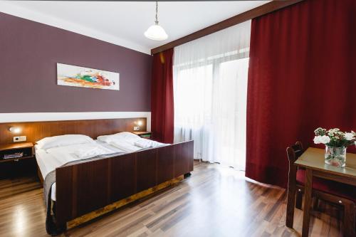 um quarto com uma cama grande e uma mesa em Hotel Hoffinger em Viena