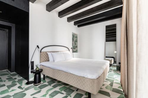 ein Schlafzimmer mit einem weißen Bett und einem grünen Boden in der Unterkunft Concepcio by Nobis, Palma, a Member of Design Hotels in Palma de Mallorca