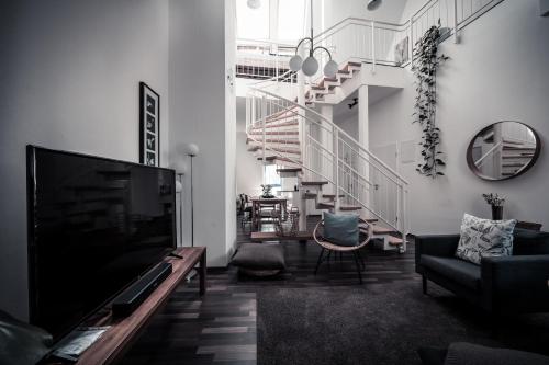 a living room with a tv and a staircase at Sommers Hotel Altes Posteck in Reichenbach im Vogtland